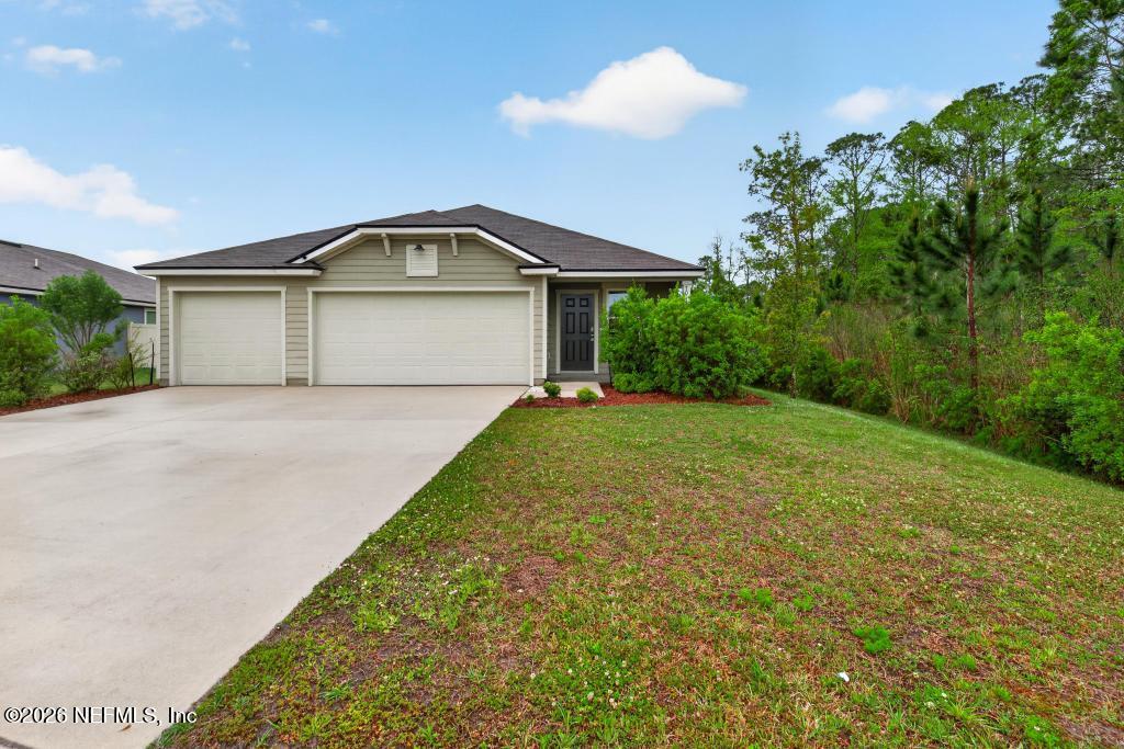 70144 Roseapple Court Yulee, FL 32097 - Photo 3 of 41 a front view of a house with a yard and garage