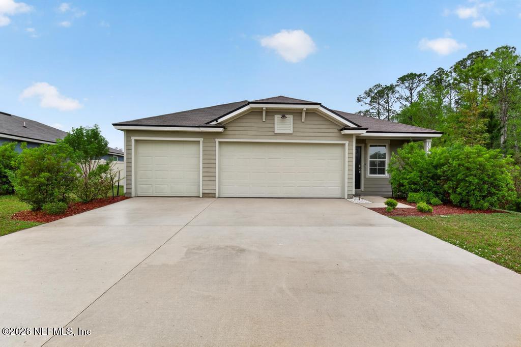 70144 Roseapple Court Yulee, FL 32097 - Photo 4 of 41 a front view of a house with a yard and garage