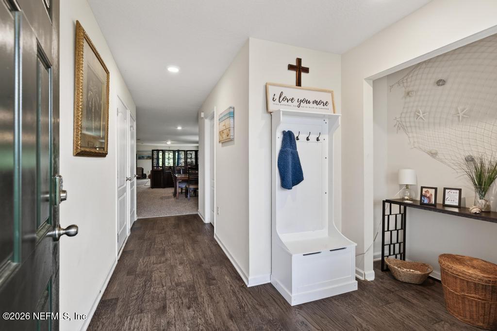 70144 Roseapple Court Yulee, FL 32097 - Photo 6 of 41 a view of a hallway with wooden floor and furniture