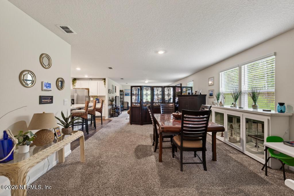 70144 Roseapple Court Yulee, FL 32097 - Photo 7 of 41 a dining room with furniture a rug and a large window