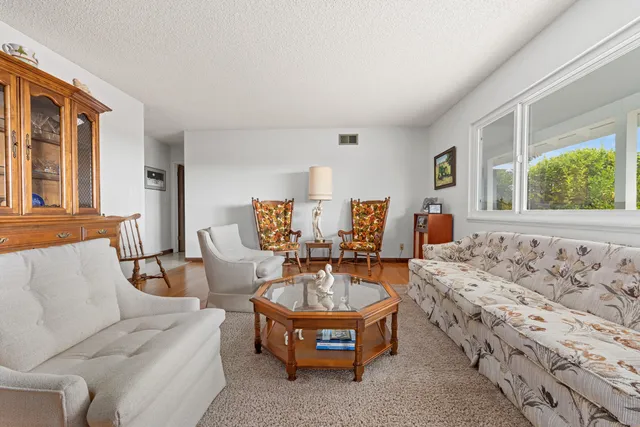 a living room with furniture a window and a chandelier