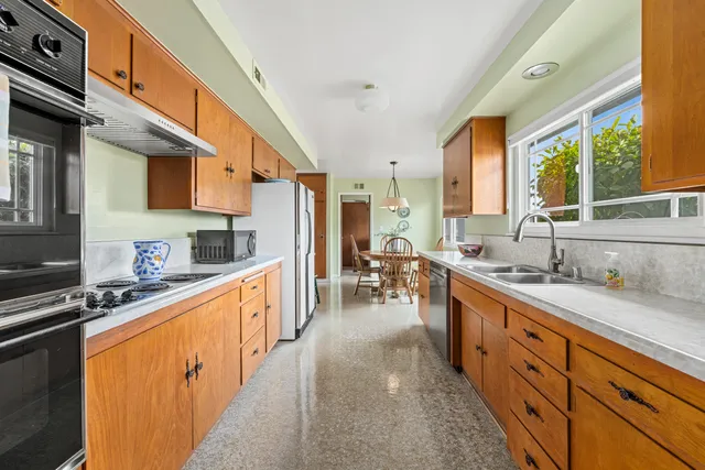 a kitchen with stainless steel appliances granite countertop sink stove top oven and cabinets