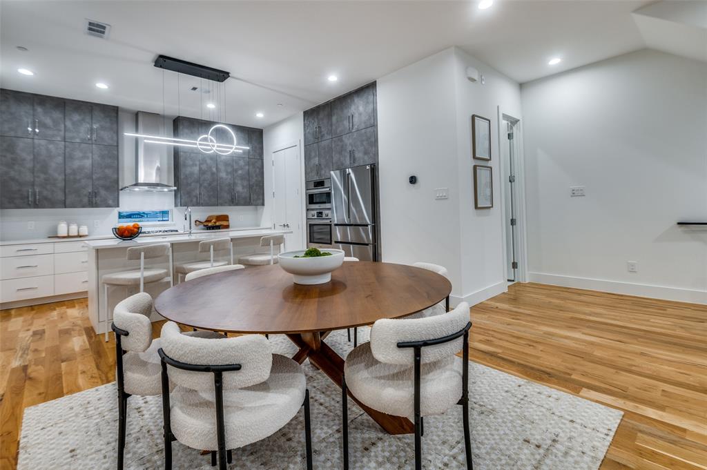 14911 Reserve Circle Addison, TX 75001 - Photo 6 of 18 a kitchen with stainless steel appliances kitchen island a dining table and chairs