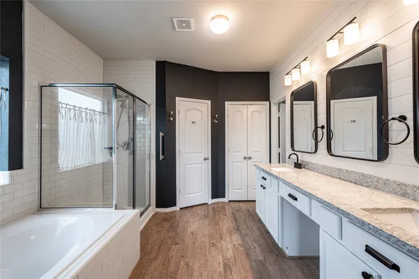 a spacious bathroom with a granite countertop sink mirror and a bathtub