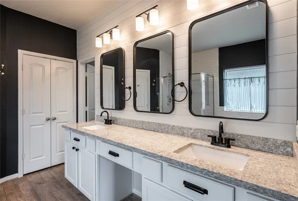 a bathroom with a granite countertop double vanity sinks and a mirror