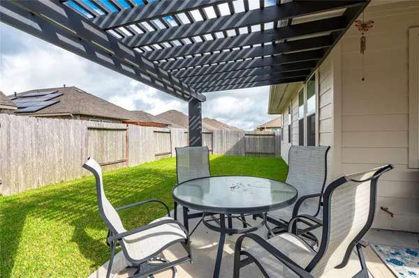 a view of a chair and table in backyard of the house