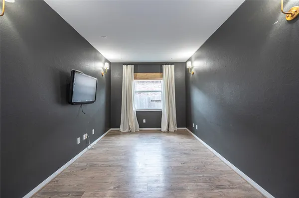 an empty room with windows and fireplace