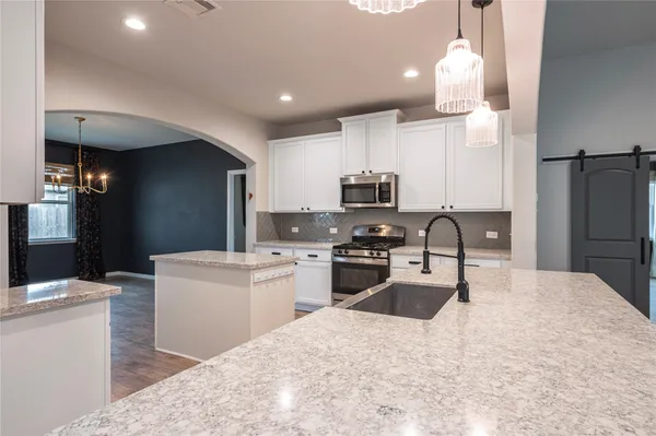a kitchen with stainless steel appliances kitchen island a refrigerator sink and stove