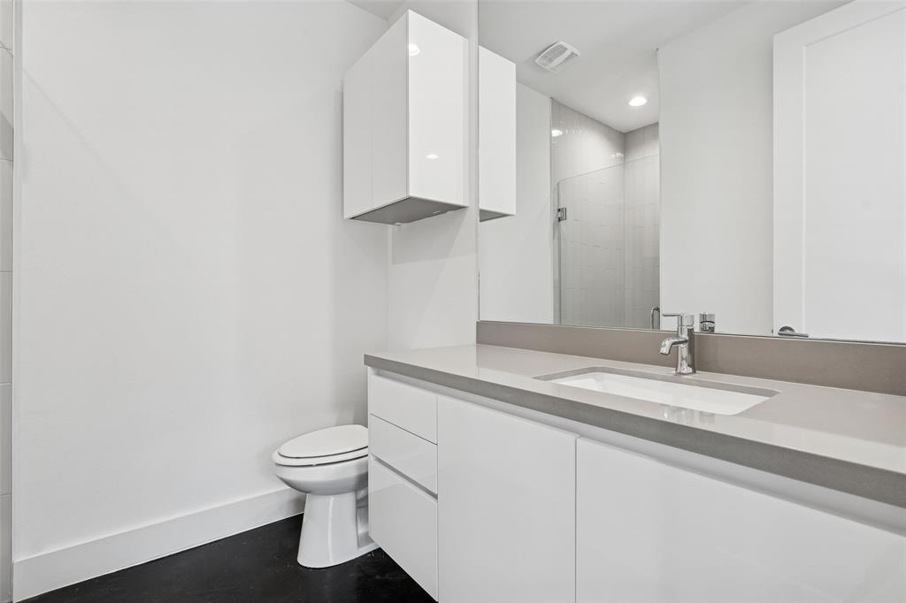 3048 ChImes Street Dallas, TX 75219 - Photo 26 of 35 a bathroom with a granite countertop sink a toilet and a mirror