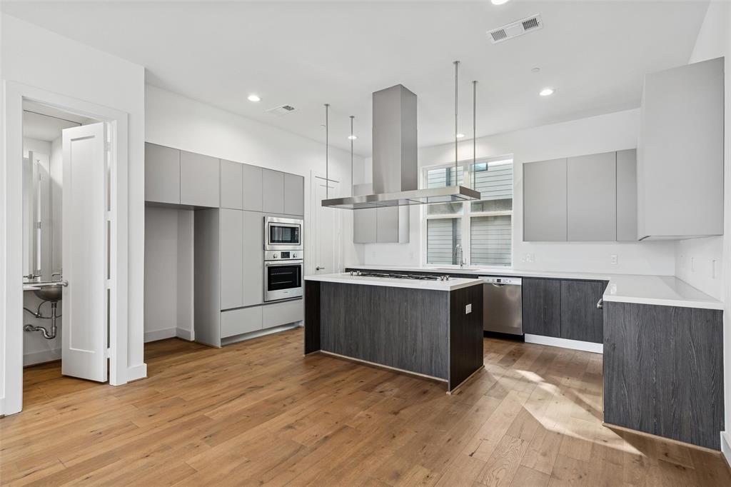 3048 ChImes Street Dallas, TX 75219 - Photo 10 of 35 a large kitchen with stainless steel appliances kitchen island granite countertop a large counter top and wooden cabinets