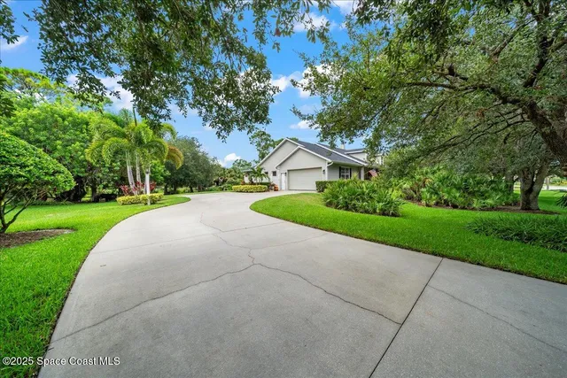 a view of a house with a yard and pathway
