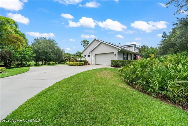 a view of house with yard and green space