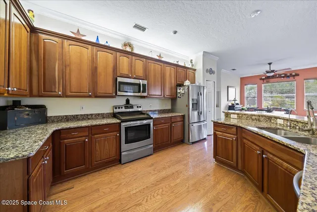 a kitchen with stainless steel appliances granite countertop a stove top oven a sink dishwasher a refrigerator and a microwave