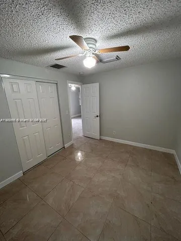 an empty room with closet and windows