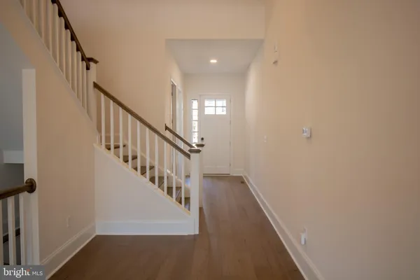 a view of a hallway with wooden floor and entryway