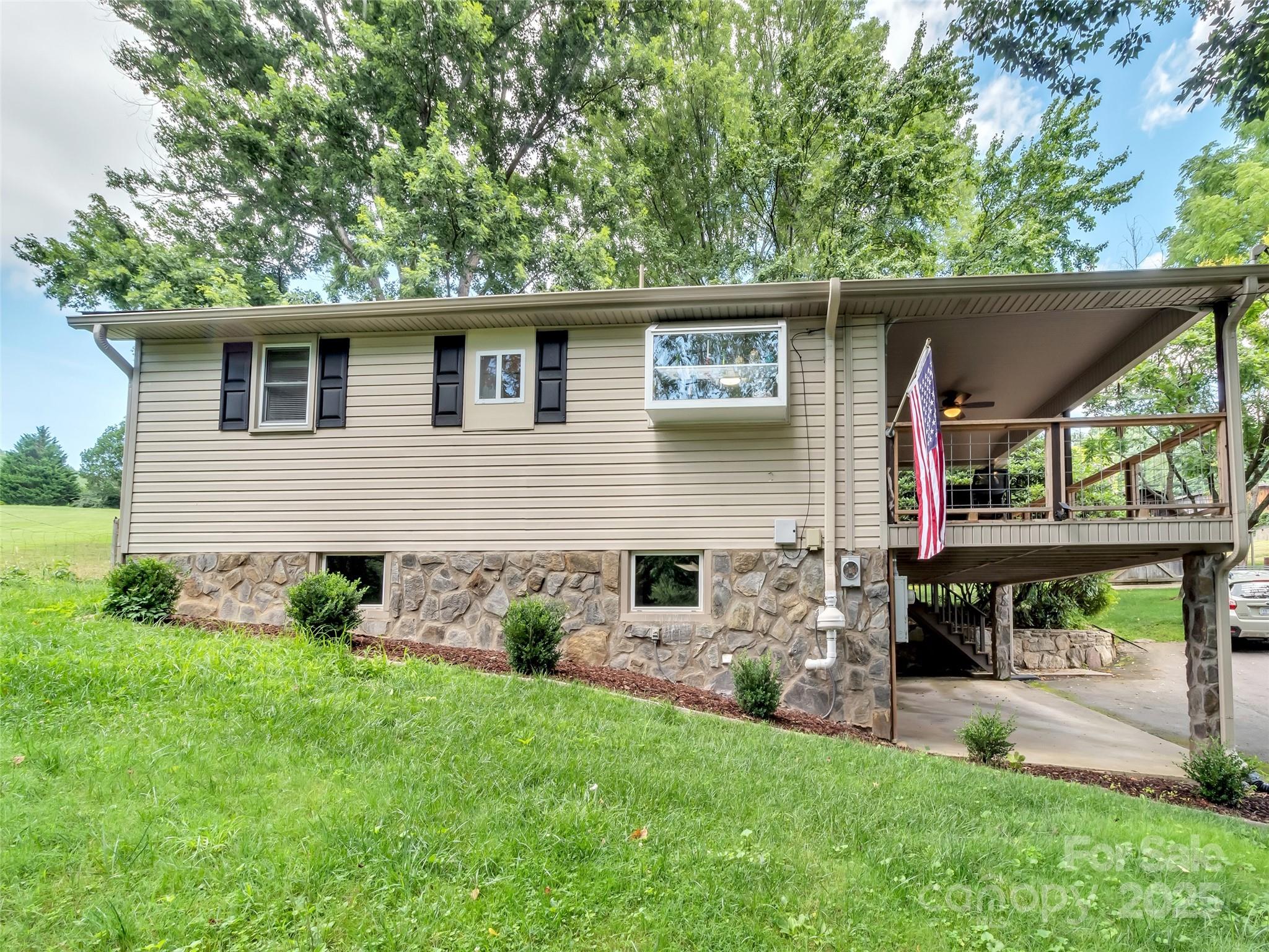 340 Mauney Cove Road Waynesville, NC 28786 - Photo 3 of 35 a view of house with a big yard potted plants and large tree