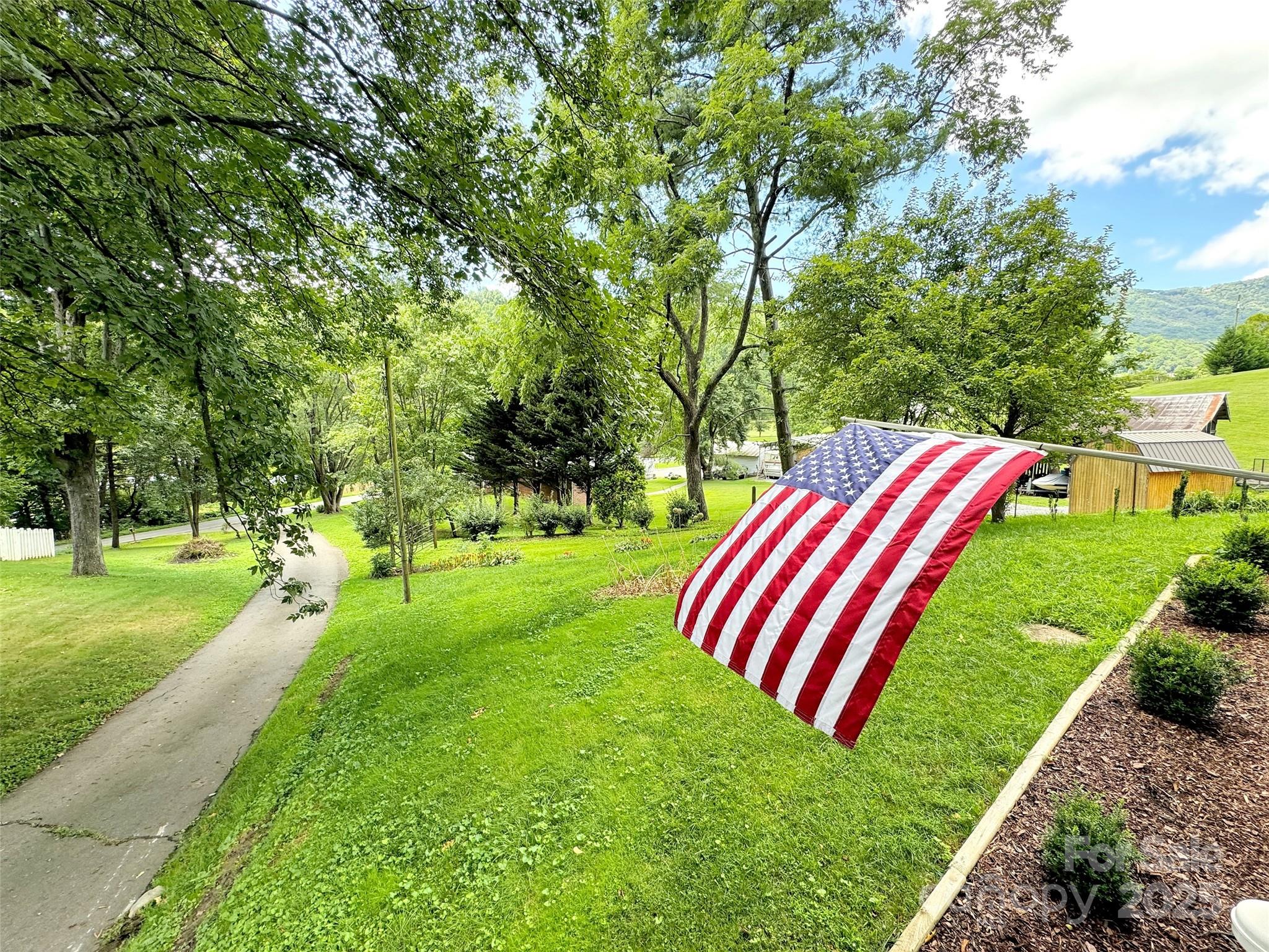 340 Mauney Cove Road Waynesville, NC 28786 - Photo 5 of 35 a front view of a house with swimming pool and garden