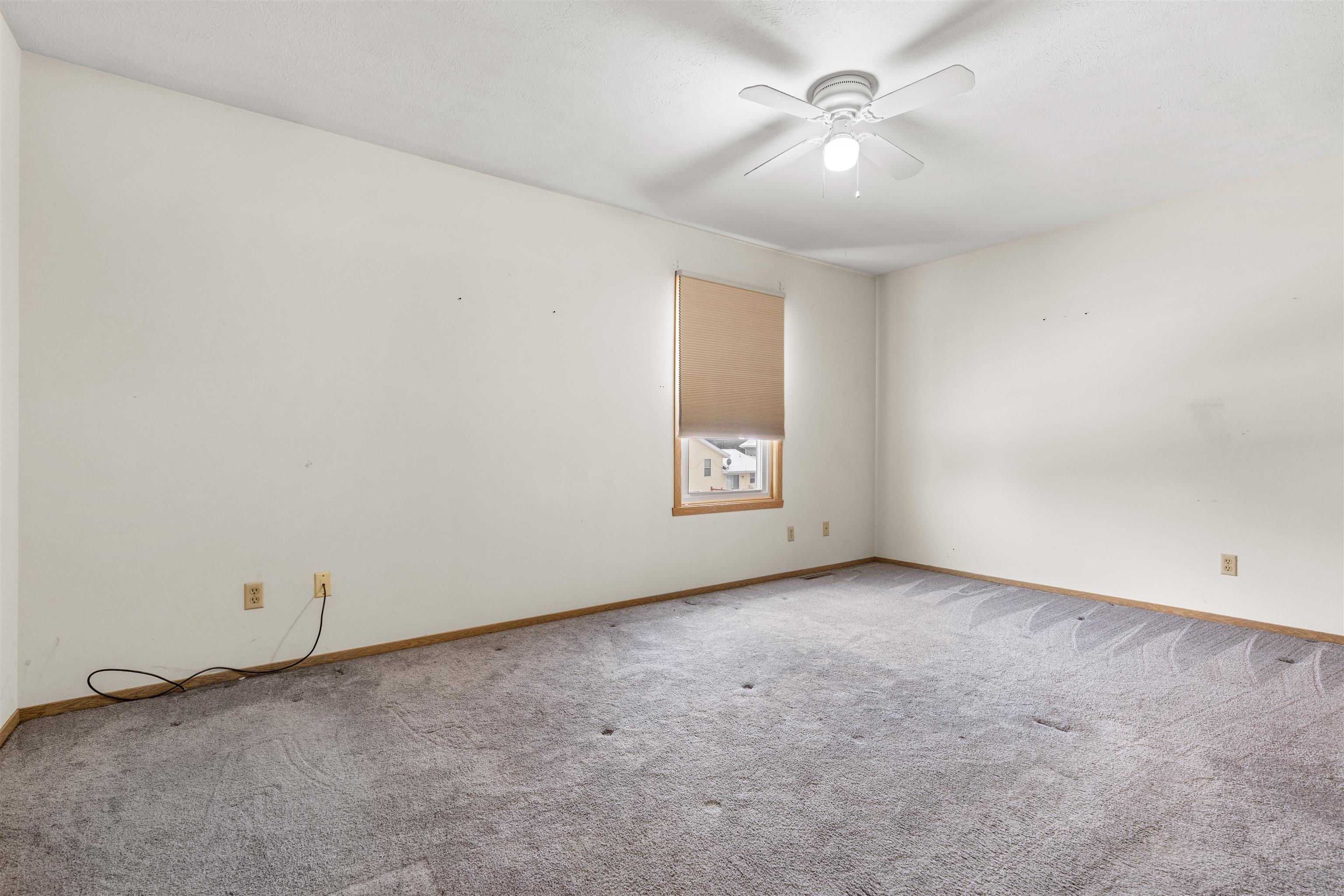 4193 Old Gate Road Rockford, IL 61109 - Photo 5 of 18 an empty room with a chandelier fan and windows