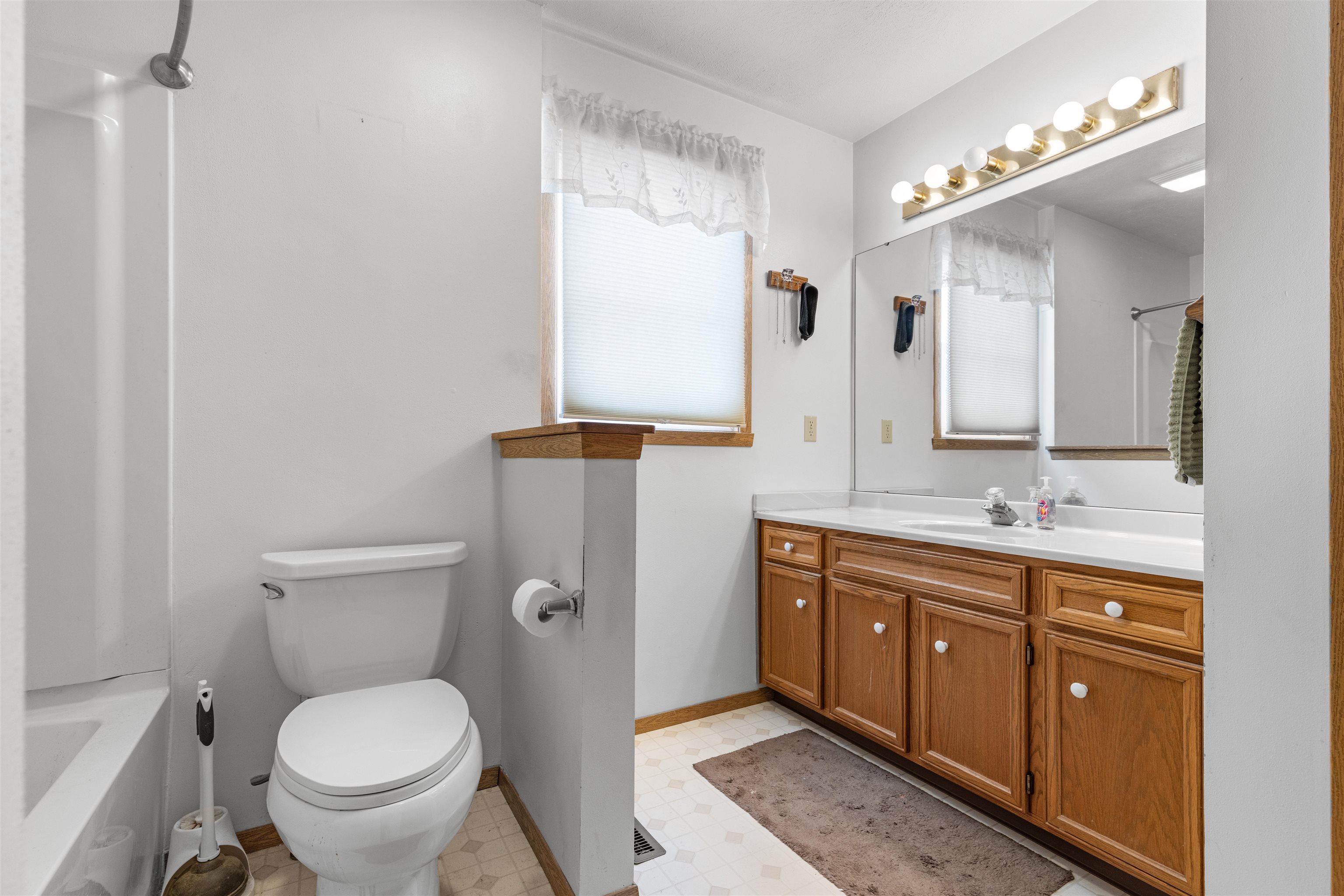 4193 Old Gate Road Rockford, IL 61109 - Photo 8 of 18 a spacious bathroom with a granite countertop toilet a sink and a mirror