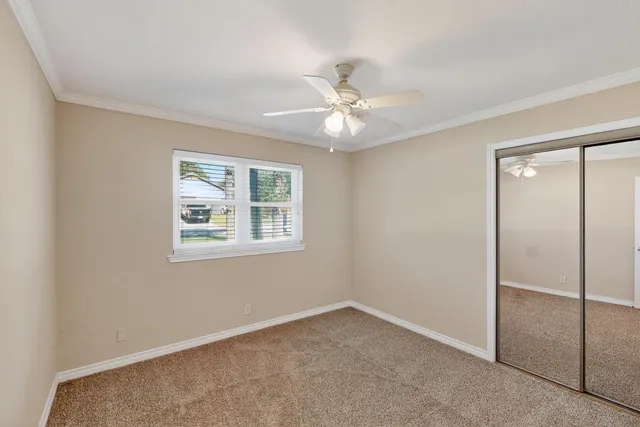 a view of an empty room with a chandelier fan
