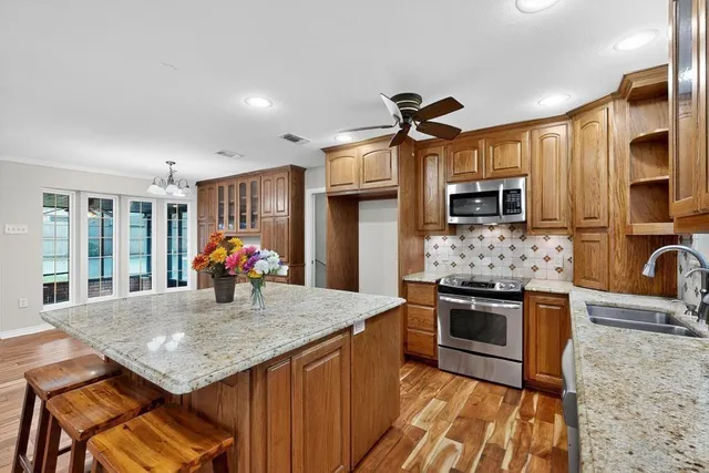 a kitchen with stainless steel appliances granite countertop a sink a stove and a refrigerator