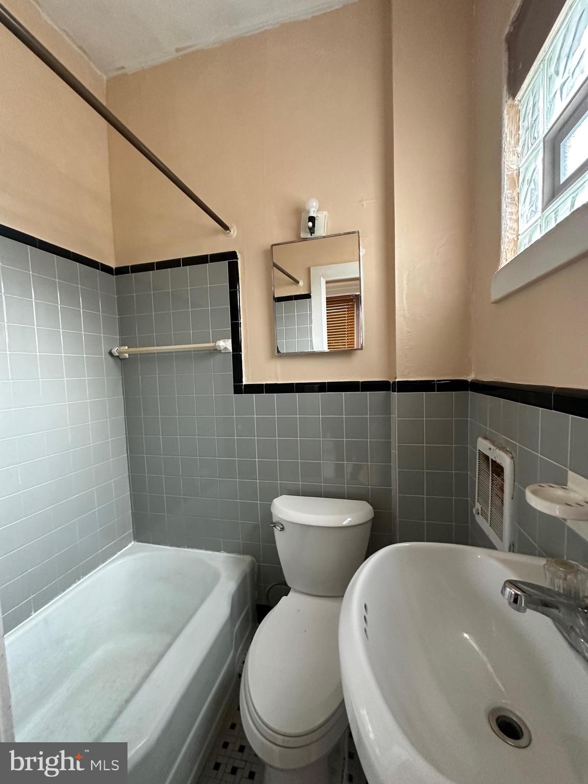 1205 Arrott Street Philadelphia, PA 19124 - Photo 3 of 3 a bathroom with a sink a toilet and mirror