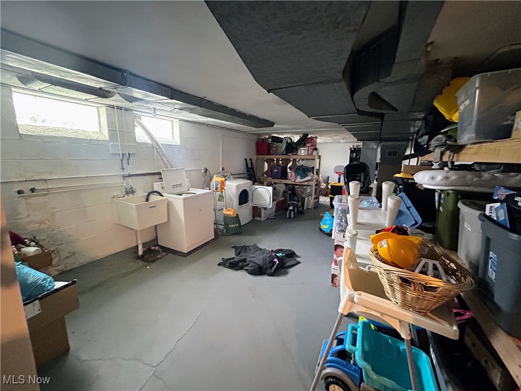 13678 Cedar Road Cleveland, OH 44118 - Photo 9 of 24 Basement (lower unit) featuring washing machine and dryer, concrete block wall, and a sink