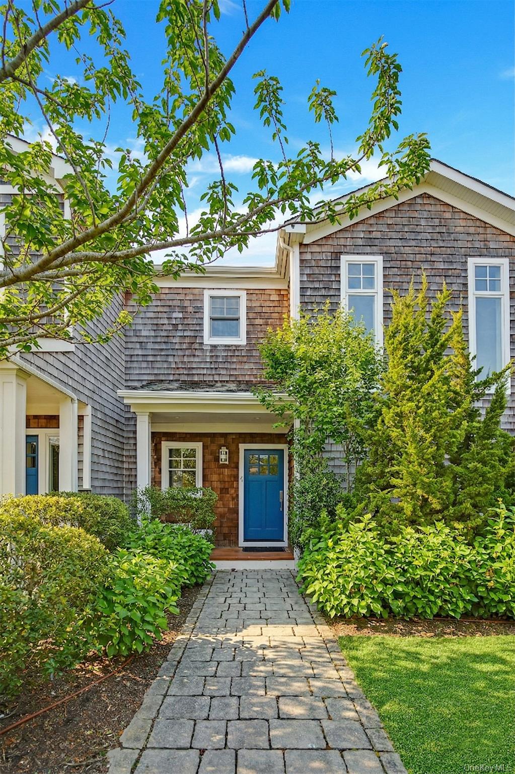 68 Foster Avenue, Unit 4 Hampton Bays, NY 11946 - Photo 1 of 17 a front view of a house with garden