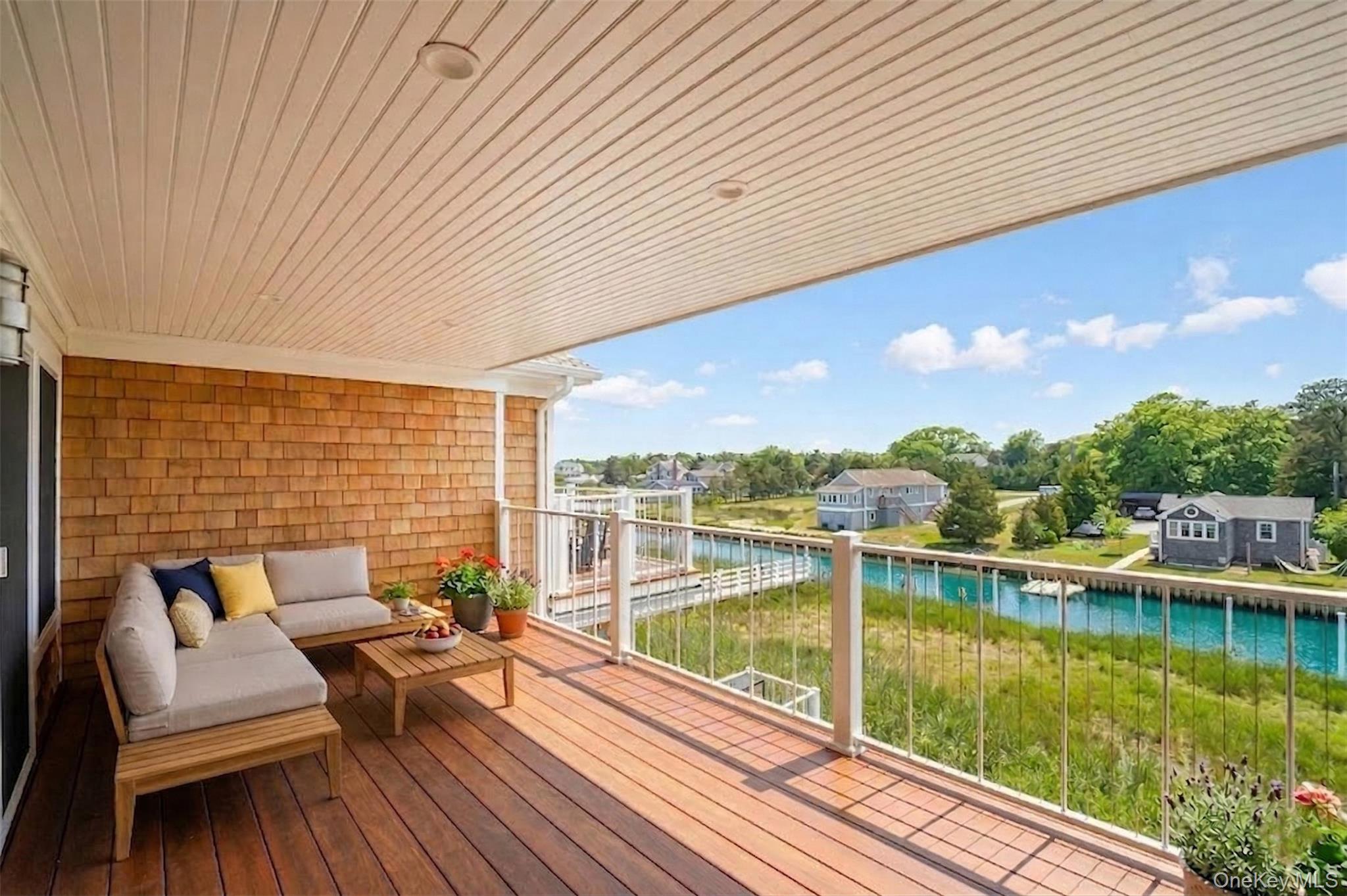 68 Foster Avenue, Unit 4 Hampton Bays, NY 11946 - Photo 7 of 17 a view of a patio with chairs next to a yard