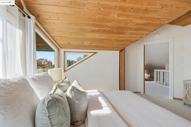 a bed sitting in a bedroom next to a window