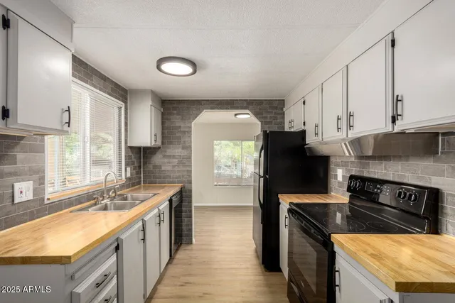 a kitchen with stainless steel appliances granite countertop a sink a stove and a refrigerator