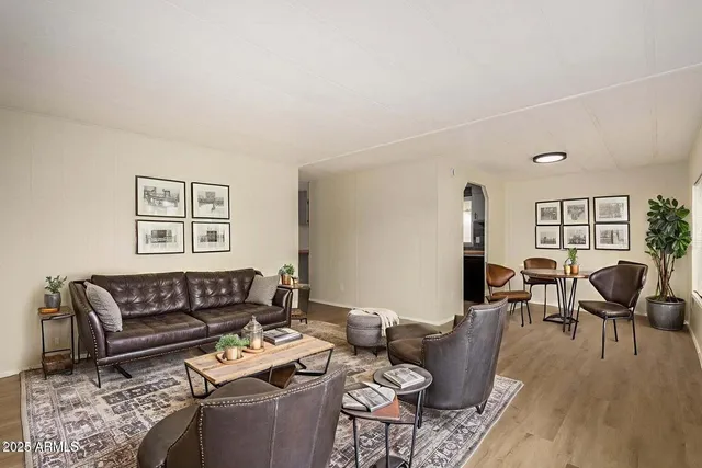 a living room with furniture a wooden floor and next to a window
