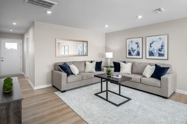 a living room with furniture a rug and a wooden floor