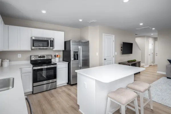 a kitchen with stainless steel appliances a stove top oven a refrigerator a sink and a stove