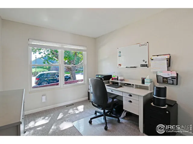 a view of a workspace with furniture and a window