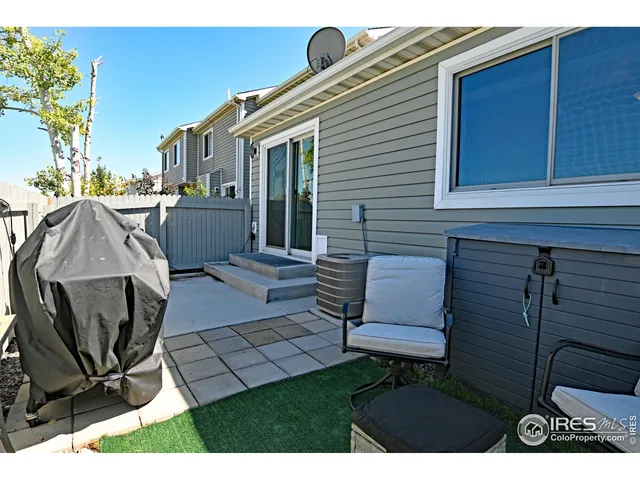 a view of backyard with seating space and wooden fence