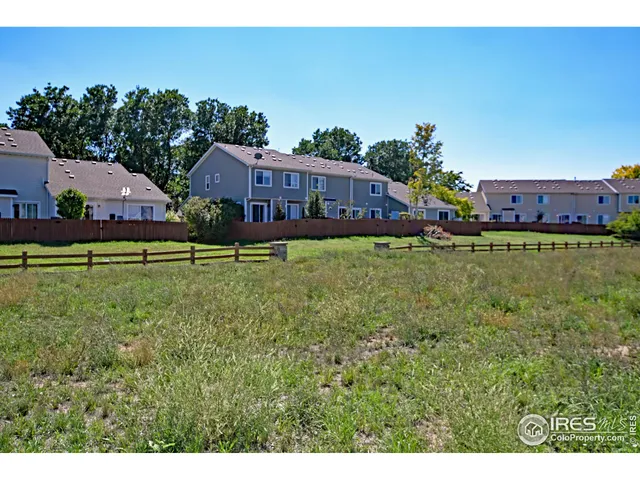a view of a big house with a big yard and large tree