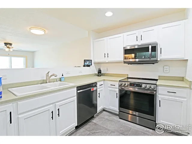 a kitchen with stainless steel appliances granite countertop a sink stove oven and white cabinets