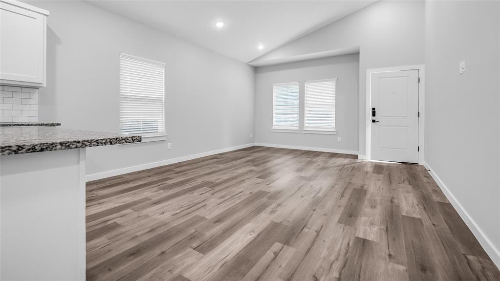 716 East Chestnut Street Denison, TX 75021 - Photo 8 of 26 Spacious interior featuring wood-finish flooring, vaulted ceiling, recessed lighting, and a white paneled entry door