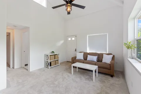 a living room with furniture and a ceiling fan