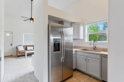 a kitchen with kitchen island a sink stainless steel appliances and a window