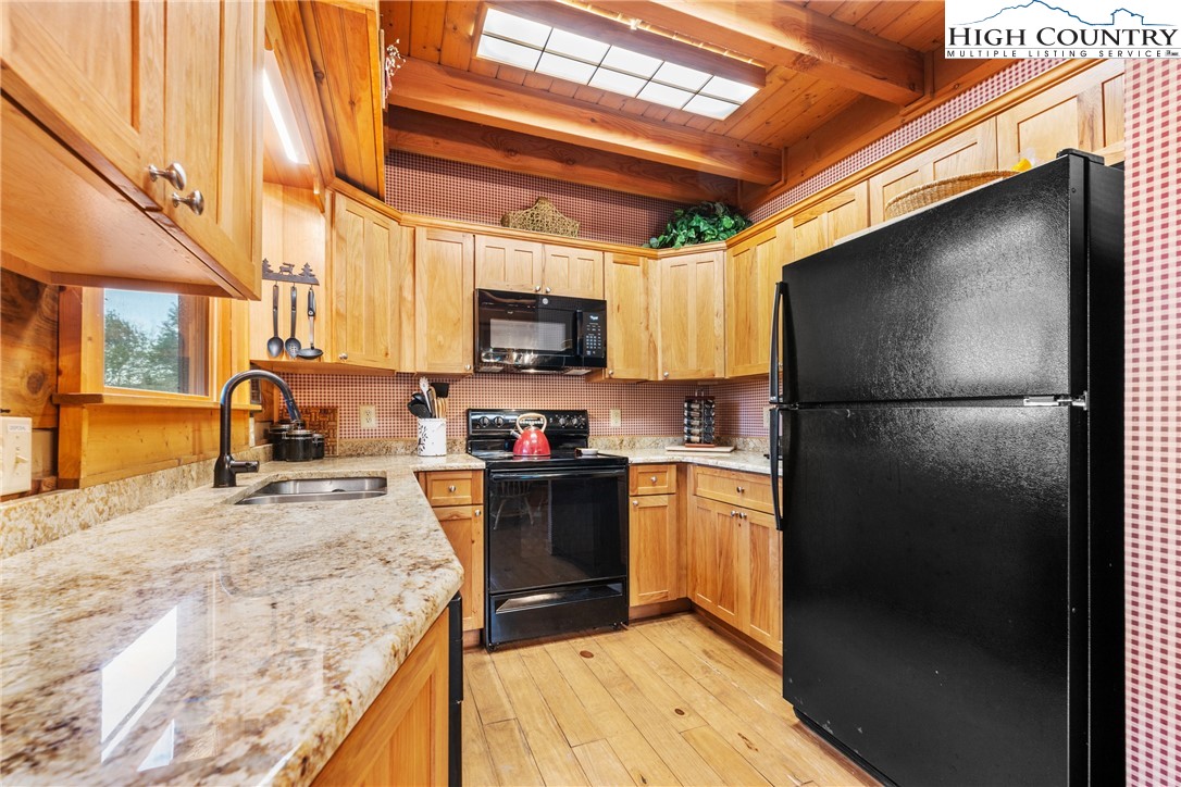 207 Lake Road Beech Mountain, NC 28604 - Photo 15 of 32 a kitchen with stainless steel appliances granite countertop a refrigerator a stove a sink and a microwave