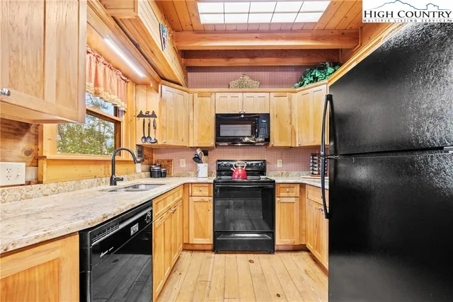 a kitchen with stainless steel appliances granite countertop a sink a stove and a refrigerator
