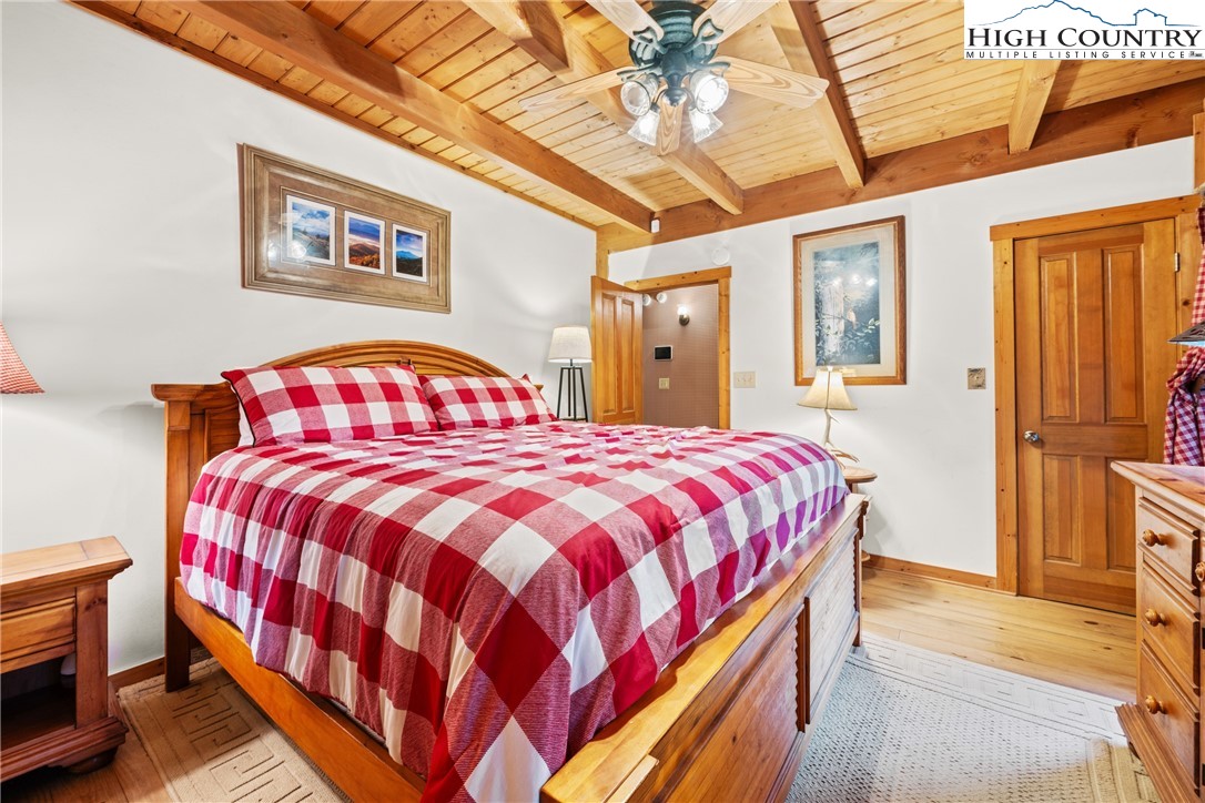 207 Lake Road Beech Mountain, NC 28604 - Photo 19 of 32 a bedroom with a bed and a chandelier