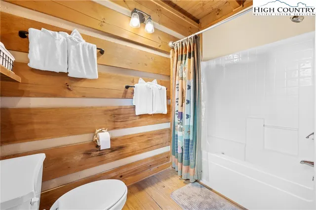 a bedroom with two beds and wooden floor