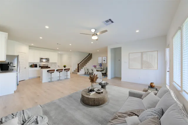 a living room with furniture and kitchen view