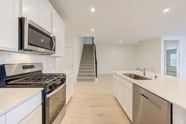 a kitchen that has a sink and a stove top oven