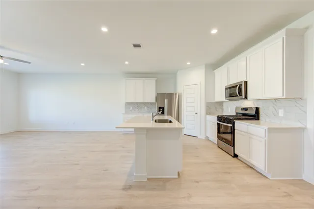 a large kitchen with stainless steel appliances lots of counter top space
