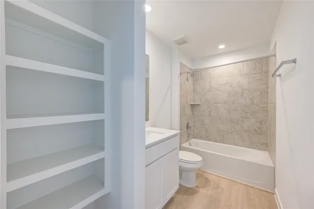 a bathroom with a shower a toilet and a tub