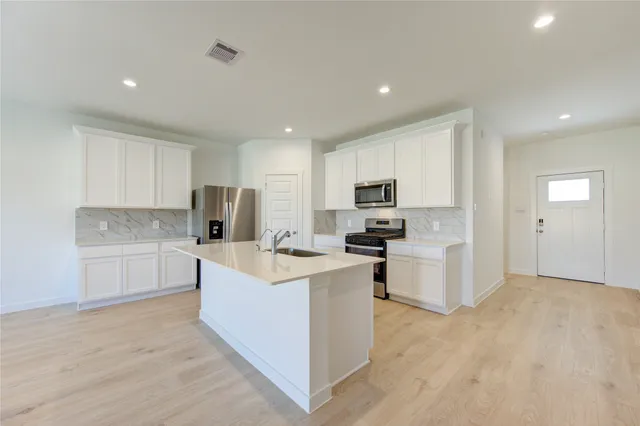 a kitchen with white cabinets and stainless steel appliances